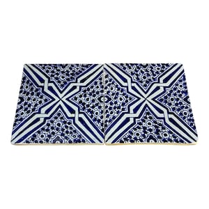 May include: Two square ceramic tiles with a repeating geometric pattern in white and navy blue. The design features a central cross shape with radiating lines and circular motifs, creating a symmetrical and decorative appearance.