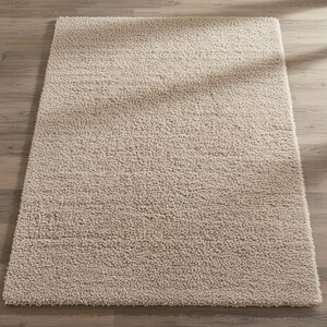 Mustard hand-tufted shag rug in a modern living room; soft yellow solid-color wool rug on light wood floor.