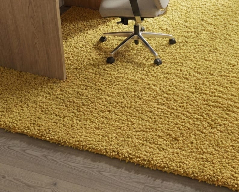 Mustard hand-tufted shag rug in a modern living room; soft yellow solid-color wool rug on light wood floor.