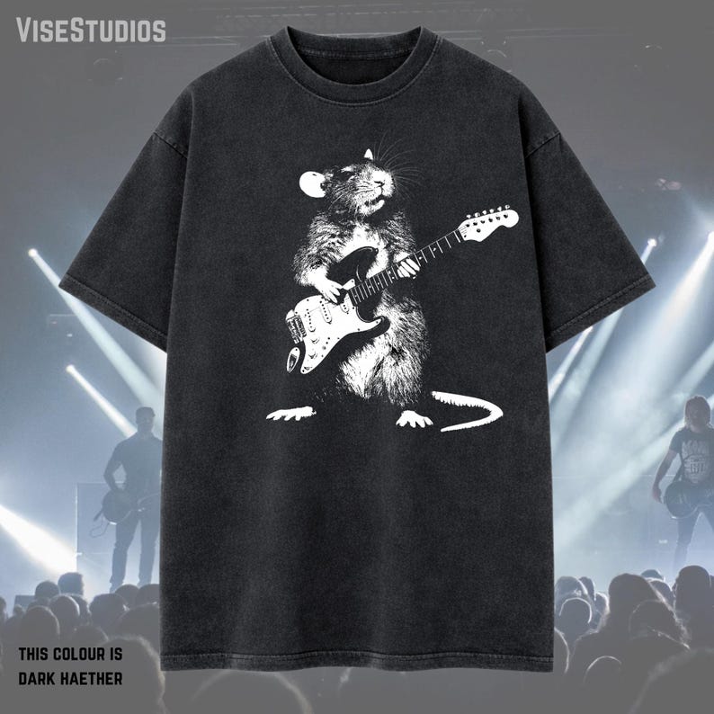 May include: Dark heather gray t-shirt featuring a white illustration of a rat playing an electric guitar. The text "THIS COLOUR IS DARK HAETHER" is at the bottom. The shirt has short sleeves and a crew neck.