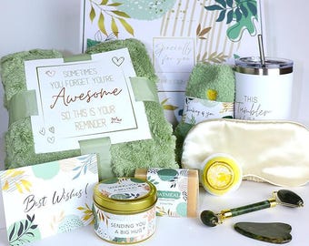 May include: A gift box with a green blanket, a white tumbler, a sleep mask, a candle, a soap bar, a bath bomb, a jade roller, and a card that says "Sometimes You Forget You're Awesome". The box is decorated with floral designs.