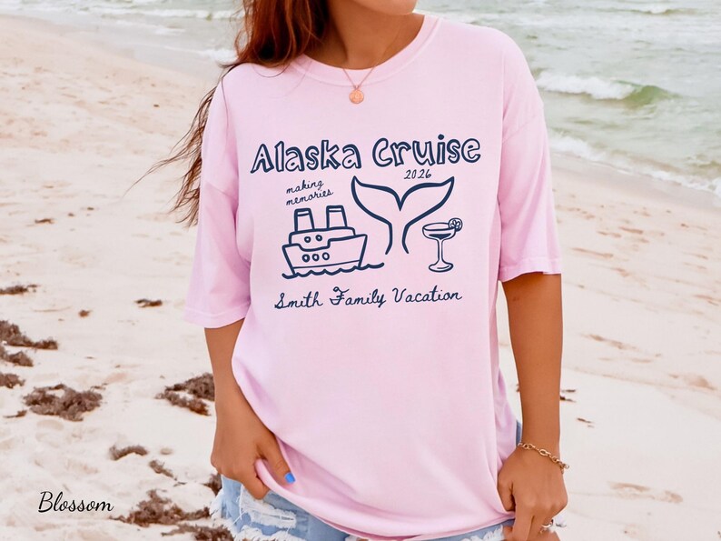 May include: Light pink t-shirt with a navy blue graphic that reads "Alaska Cruise 2026" with a ship, whale tail, and cocktail illustration. The text "making memories" and "Smith Family Vacation" are also included.