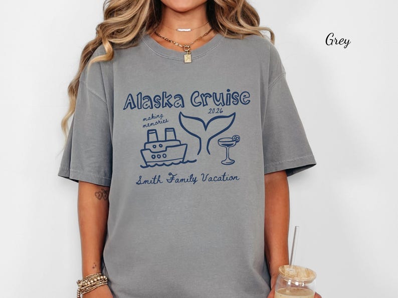 May include: Grey t-shirt with a navy blue graphic that reads "Alaska Cruise 2026" with a ship, whale tail, and cocktail illustration. The text "making memories" and "Smith Family Vacation" are also included.