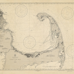 May include: A vintage nautical chart of Cape Cod Bay, Massachusetts. The chart is printed in black and white on a cream-colored paper. It shows the coastline of Cape Cod, including the towns of Provincetown, Chatham, and Falmouth. The chart also includes a compass rose and a scale bar.