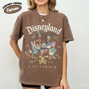 K&ouml;nnte beinhalten: Eine wei&szlig;e Keramik-Tasse mit schwarzem Henkel und dem Text "But First, Coffee" in handschriftlichem Stil. Die Tasse steht auf einer wei&szlig;en Oberfl&auml;che. Die Tasse ist 10 cm hoch.