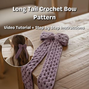 Op de afbeelding: Een lila gehaakte strik met lange staarten, gepresenteerd op een houten tafel. De afbeelding bevat de tekst "Long Tail Crochet Bow Pattern" en "Video Tutorial + Step by Step Instructions". Een cirkelvormige inzet toont de strik in gebruik.
