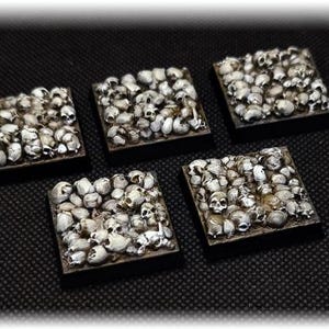 Puede incluir: Cinco baldosas cuadradas, cada una cubierta con una multitud de pequeñas calaveras blancas. Las calaveras están densamente empaquetadas, creando una superficie texturizada. Las baldosas tienen bordes marrones oscuros, sobre fondo negro.