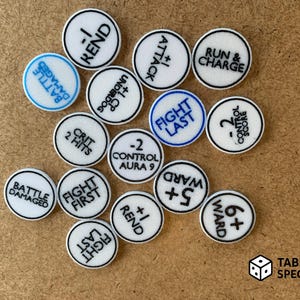 May include: A collection of white, circular game tokens with black borders and various text inscriptions in black and blue. The tokens include phrases like "Fight Last", "Ward +5", and "Battle Damaged". The Tabletop Specialist logo is in the bottom right.