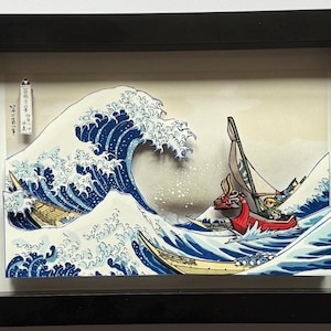 Pode incluir: Obra de arte emoldurada retratando uma cena oce&acirc;nica estilizada com uma grande onda azul e barcos. A obra apresenta um barco vermelho com um personagem e uma est&eacute;tica de estilo japon&ecirc;s. A moldura &eacute; preta.