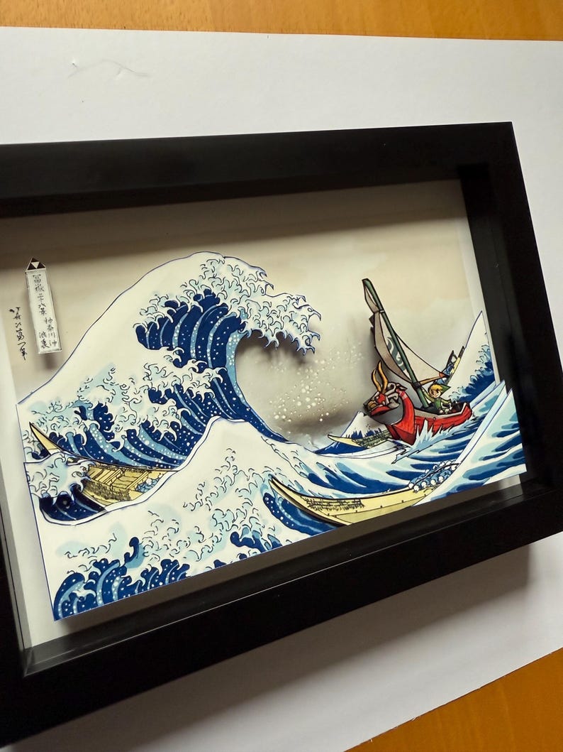 Pode incluir: Uma obra de arte 3D emoldurada que retrata uma onda oce&acirc;nica estilizada com barcos. A onda &eacute; renderizada em tons de azul e branco, com um barco em primeiro plano e dois outros ao fundo. A obra de arte &eacute; emoldurada em preto.