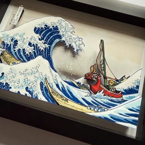 Pode incluir: Uma obra de arte 3D emoldurada que retrata uma onda oce&acirc;nica estilizada com um barco e personagens. A onda &eacute; renderizada em tons de azul e branco, com um barco e personagens na crista. A obra de arte &eacute; emoldurada em uma moldura preta.