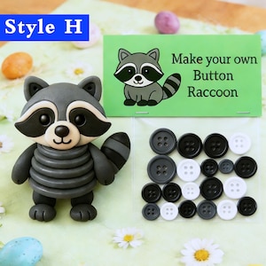 May include: A grey raccoon figure with black details and a striped tail, beside a green card reading "Make your own Button Raccoon." Various black, white, and grey buttons are also present.