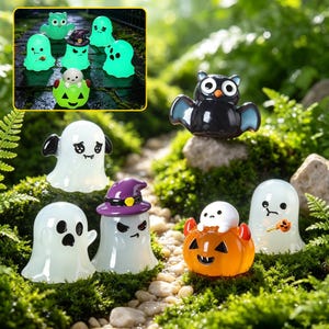 Może przedstawiać: Kolekcja miniaturowych figurek na Halloween, w tym białe duszki o różnych wyrazach twarzy, duszek w fioletowym kapeluszu czarownicy, mały biały duszek siedzący na pomarańczowej dyni oraz czarny nietoperz z dużymi białymi oczami.