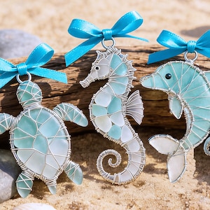 May include: A white ceramic mug with a black handle and the text "But First, Coffee" in a black, handwritten-style font. The mug is on a white surface.