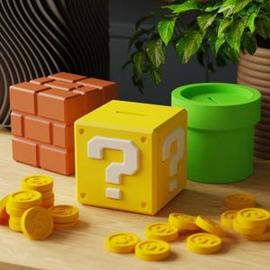 May include: A yellow cube-shaped money box featuring a white question mark on the side, alongside an orange brick block, a green pipe-shaped container, and several small yellow circular coins scattered on the surface.