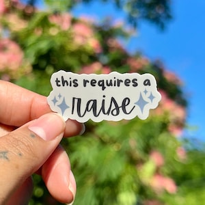 May include: A white die-cut sticker with a wavy edge featuring the black text this requires a raise and light blue four-pointed star icons. The sticker has a smooth matte finish and is shaped to follow the contour of the printed lettering.
