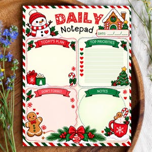 Könnte beinhalten: Ein Tagesplaner-Block mit Weihnachtsmotiven wie Schneemann, Lebkuchenhaus, Zuckerstangen, Geschenken und Lebkuchenmann. Die Seite enthält Bereiche für Tagespläne, Prioritäten, Notizen und Erinnerungen, umrahmt von einem rot-weiß gestreiften Rand.