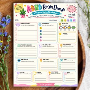 Op de afbeelding: Een kleurrijk ADHD Brain Dump & Productivity Worksheet met secties voor prioriteiten, energieniveaus, taken en afspraken. Het blad bevat een roze hersenillustratie, een plant in een pot en tekstvakken om gedachten en doelen te ordenen.
