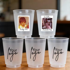 May include: Five frosted plastic cups. Two cups have photo stickers that read "Vintage 1975" and "Isabella's Bachelorette Party". The other three cups have the words "Your Logo" in a cursive font.