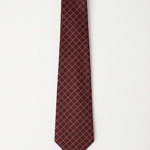 Puede incluir: Una corbata burdeos con un patrón de cuadrícula repetido en un tono más claro de rojo. La corbata está hecha de una tela suave y se muestra sobre un fondo blanco. Un accesorio clásico para vestimenta formal o de negocios.