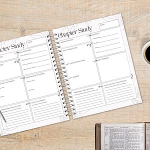 May include: Open spiral-bound notebook with "Character Study" and "Chapter Study" headings, featuring fill-in sections for notes. A pen rests on the page. A cup of coffee and a candle are on the wooden surface.
