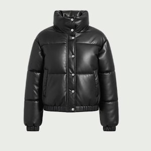 Könnte beinhalten: Schwarze Pufferjacke mit hohem Kragen und silbernen Druckknöpfen. Die Jacke hat ein gestepptes Design und gerippte Manschetten. Die Jacke besteht aus einem glänzenden Kunstledermaterial. Die Jacke ist ein Cropped-Style.