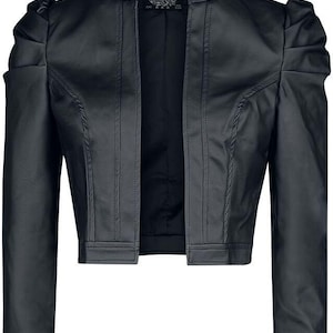 May include: Black cropped jacket with a stand-up collar and puffed sleeves. The jacket features vertical seams and a tailored fit. The open front design and cropped length create a stylish silhouette. The jacket is made of a smooth, dark material.