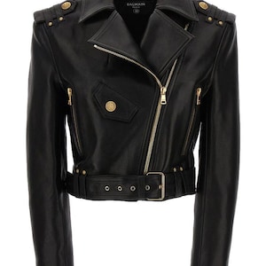 May include: Black leather jacket with a classic biker style. Features an asymmetrical zipper, a belted waist, and gold-tone hardware. The jacket has shoulder epaulets with decorative buttons and a small pocket.