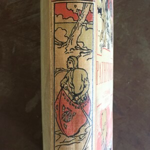 May include: A vintage book with a tan cloth cover and black and red illustrations. The title "Pathfinder" is visible on the spine. The book is published by Hurst & Co.