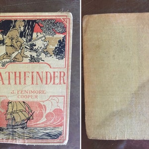 May include: A vintage book titled "PATHFINDER" by J. FENIMORE COOPER. The cover features a black and white illustration of a man in a forest with a rifle and a ship sailing on the ocean.