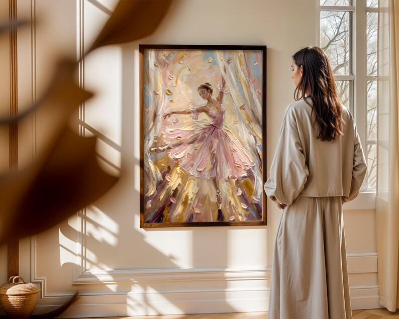 以下が含まれることがあります： ピンクのチュチュを着たバレリーナが舞い散る花びらの中で踊る様子を描いた油絵。柔らかなピンク、クリーム、ゴールドの色合いで厚く質感のある筆致が特徴で、木製の額縁の中でダイナミックな動きを捉えた作品です。
