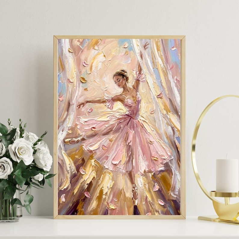 以下が含まれることがあります： 明るい木製のフレームに入った油絵で、ピンクのチュチュを着たバレリーナが、渦巻く布と舞い落ちる花びらの中で踊る様子が描かれています。作品は、ピンク、クリーム、ゴールドの色合いで、厚みのある質感の筆致が特徴です。