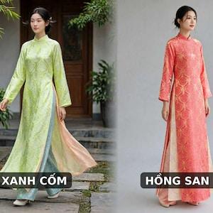 May include: Two traditional Vietnamese Ao Dai tunics with long sleeves and high collars. The left tunic is light green with a subtle floral pattern, paired with light blue trousers. The right tunic is coral pink with a gold floral pattern and cream trousers.