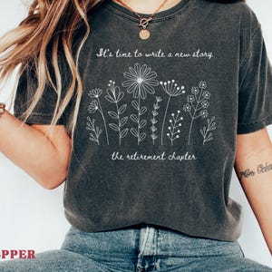 Retirement shirt with floral line art and the quote "It's time to write a new story, the retirement chapter", inspirational retirement gift for women, botanical graphic tee, thoughtful coworker farewell gift, soft casual unisex t-shirt.