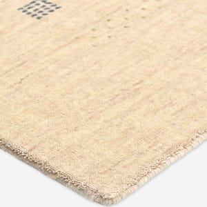 Puede incluir: Alfombra beige con superficie texturizada y dise&ntilde;o geom&eacute;trico. La alfombra presenta un patr&oacute;n cuadrado y puntos dispersos en un tono beige m&aacute;s oscuro. El borde de la alfombra est&aacute; cuidadosamente terminado con un borde sutil.