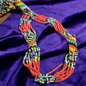 Livfullt halsband i afrikansk tribalstil - okänd tillverkare | del av etniska smyckeskollektion | orange glaspärlor med spiralformade karibiska vibbar