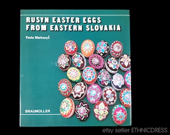 Può includere: Un libro intitolato "Rusyn Easter Eggs from Eastern Slovakia" di Pavlo Markovyc. La copertina presenta una mostra colorata di uova di Pasqua dipinte in modo intricato, mostrando l'arte popolare tradizionale rusyn.