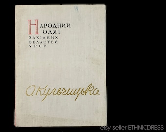 May include: A white book cover with the title "Народний одяг" in red and black text. The subtitle is "Західних областей УРСР" in black text. The author's name is "О. Куровська" in gold text.