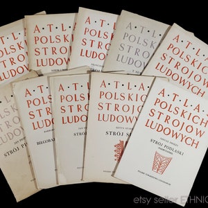 May include: A stack of vintage books titled "Atlas Polskich Strojow Ludowych" (Atlas of Polish Folk Costumes). The books are bound in white paper with red lettering and feature illustrations of traditional Polish clothing.