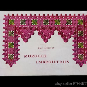 Puede incluir: Una portada de libro vintage titulada "Bordados de Marruecos" de la Biblioteca DMC. La portada presenta un diseño bordado decorativo en rosa y verde. El libro está sobre un fondo blanco.