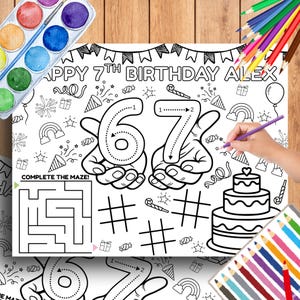 以下が含まれることがあります： 「HAPPY 7TH BIRTHDAY ALEX」の文字が入った白黒の塗り絵。6と7の数字、迷路、ケーキ、その他誕生日のイラストが描かれています。紫色の色鉛筆を持った手。