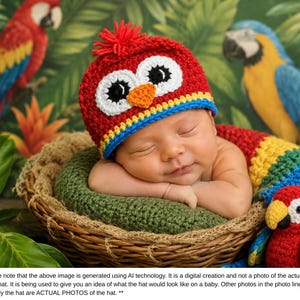Puede incluir: Un beb&eacute; dormido con un gorro y bufanda de crochet rojo, blanco y azul con forma de p&aacute;jaro, acurrucado en una cesta tejida. El fondo presenta loros y follaje tropical. El gorro tiene grandes ojos blancos y un pico naranja.
