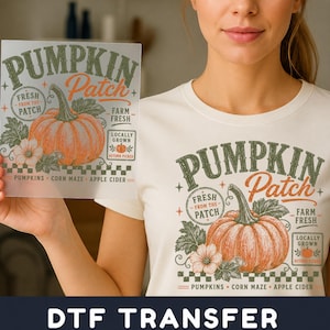 May include: A white t-shirt featuring a graphic print of an orange pumpkin with green leaves and the text PUMPKIN Patch, FRESH FROM THE PATCH, FARM FRESH, LOCALLY GROWN, PUMPKINS, CORN MAZE, and APPLE CIDER, matching the design on a transparent sheet.