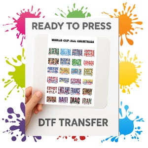 May include: A DTF transfer sheet with the text "READY TO PRESS" and "DTF TRANSFER". The sheet features a design with the text "WORLD CUP-ALL COUNTRIES" and country names like Algeria, Argentina, and Australia in various fonts and colours.