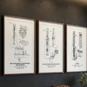 Può includere: Tre stampe incorniciate con diagrammi in bianco e nero di brevetti di strumenti a corda. Le stampe sono in cornici di legno e sono appese a una parete scura sopra un mobile di legno. Il testo include "Key Attachment for Stringed Instruments", "Device for Tuning Stringed Instruments" e "Guitar".