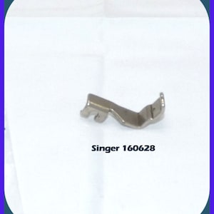 May include: A silver sewing machine foot with a curved shape. The foot is labeled "Singer 160628".