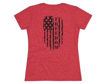 May include: Red t-shirt with a distressed American flag design on the back. The flag is black and features stars and stripes with the word "FREEDOM" printed vertically.