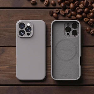 May include: Two gray phone cases, one showing the exterior and the other the interior. The exterior case is solid gray with camera cutouts. The interior case has a circular design and the text "YCADE". Coffee beans are scattered on a wooden surface.