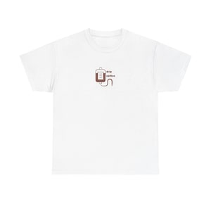 May include: White t-shirt with a small brown graphic of a coffee drip bag and the words "drip coffee" printed in brown. The shirt is made of a soft material and has a classic crew neck.