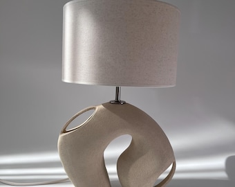 Moderne organische keramische tafellamp – gebogen sculpturale voet, beige lamp met minimale textuur